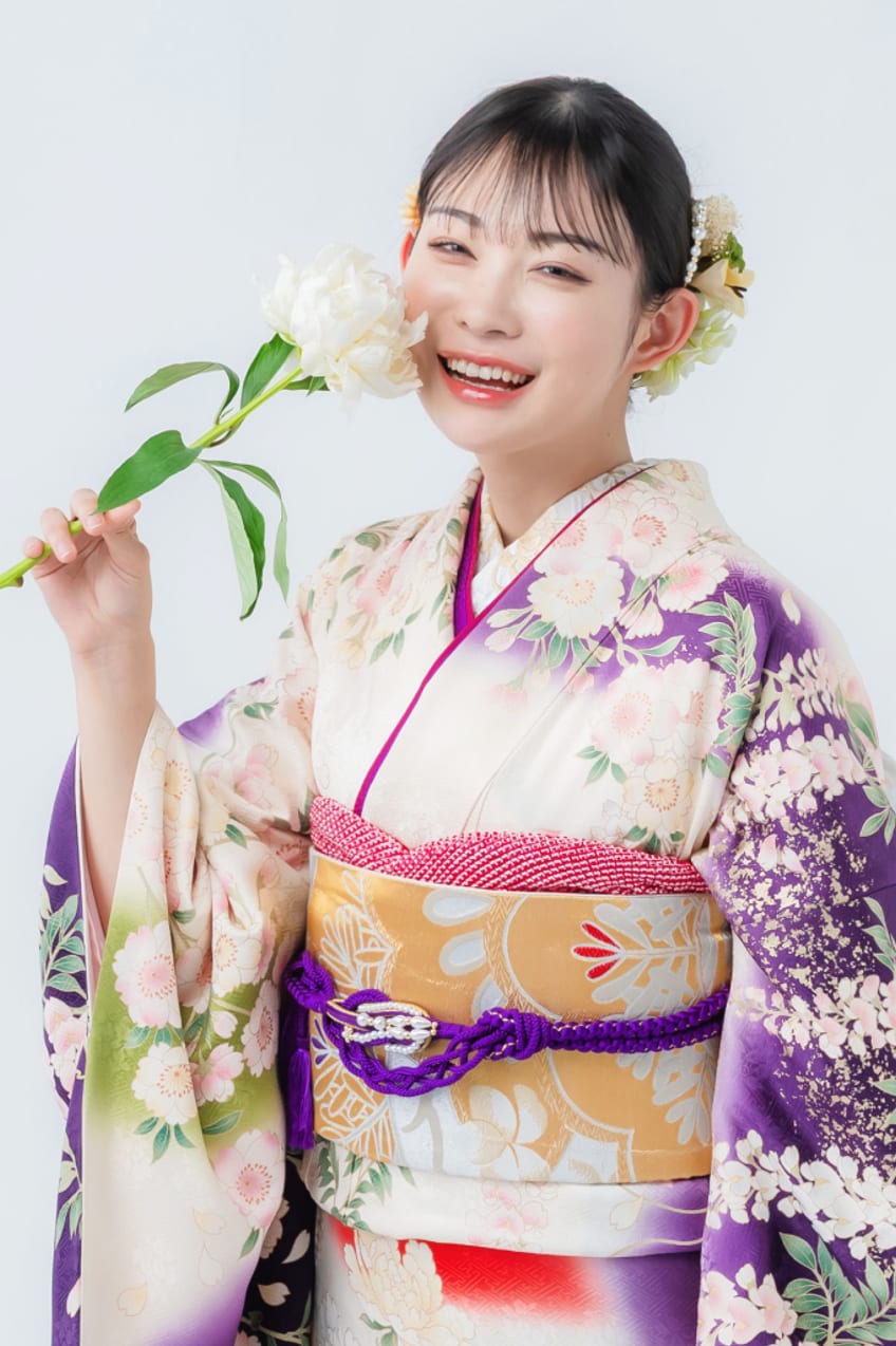 白い花を手にした振袖姿の女性